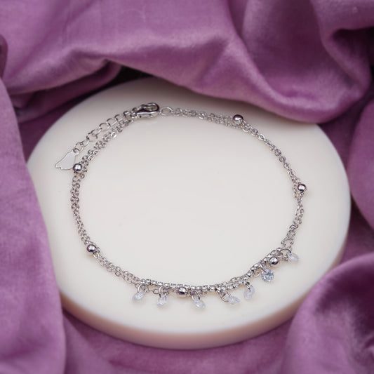 Silver-tone anklet featuring dangling teardrop crystal charms on a fine chain