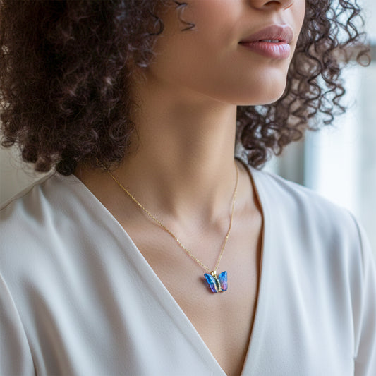 Gold butterfly pendant necklace with iridescent blue resin butterfly on gold chain