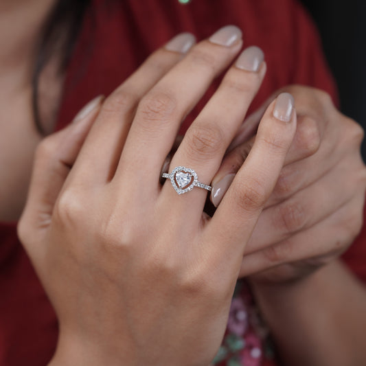 Silver heart solitaire ring with pavé halo on a woman's finger