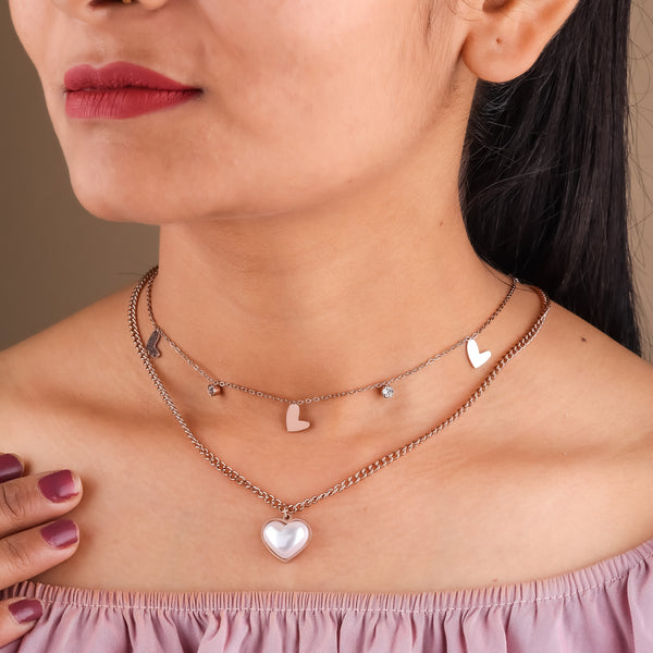 Rose gold double-layer heart charm necklace worn on neck with small hearts and heart pendant