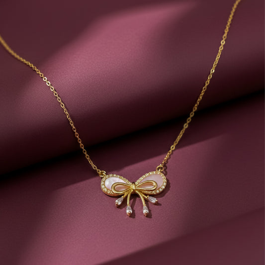 Gold bow pendant necklace with pink enamel and crystal drops