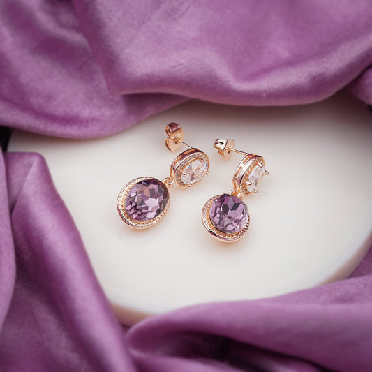 Rose gold drop earrings on display: purple oval stones with clear round halo details