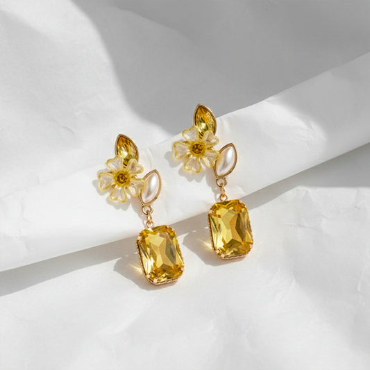 Gold-tone flower drop earrings with pearl petal charms and golden square-cut dangle stones
