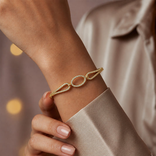 Rose gold open oval CZ bangle bracelet with linked oval stones on wrist