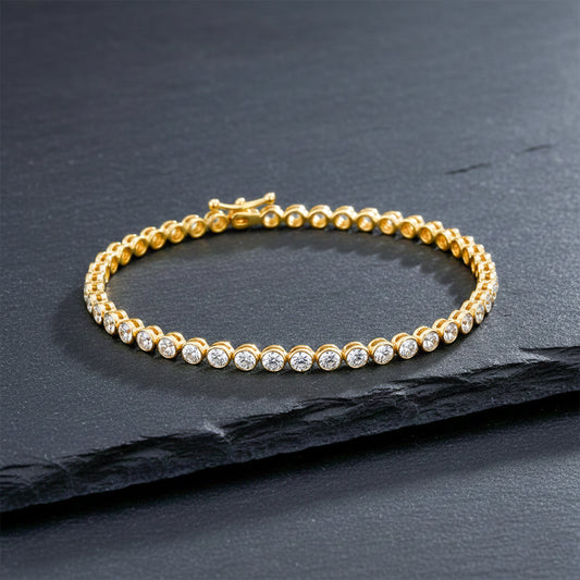 Gold-tone tennis bracelet with round clear rhinestone links and flexible chain.