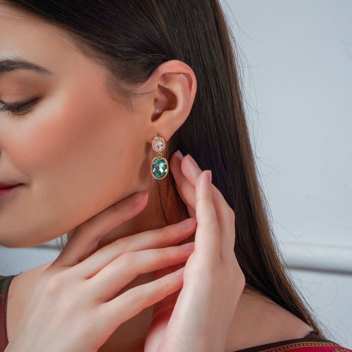 Woman wearing a blue and green drop earring