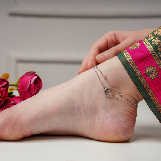Silver double-layer anklet with heart-and-circle charm on ankle