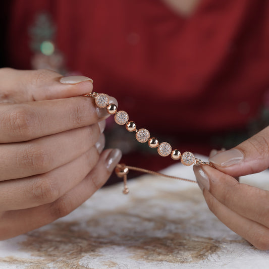 Rose gold CZ ball bracelet with glittering round stations held between hands