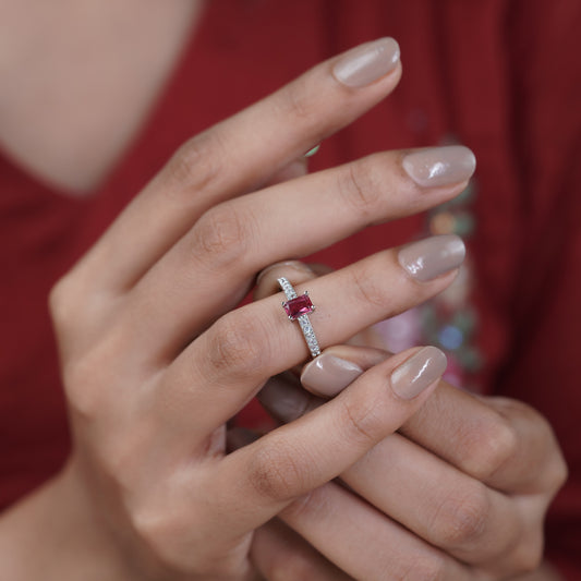 Silver pavé band ring with emerald-cut ruby stone on a woman's hand
