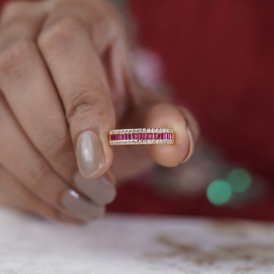 Rose gold ruby and crystal eternity ring held between fingers