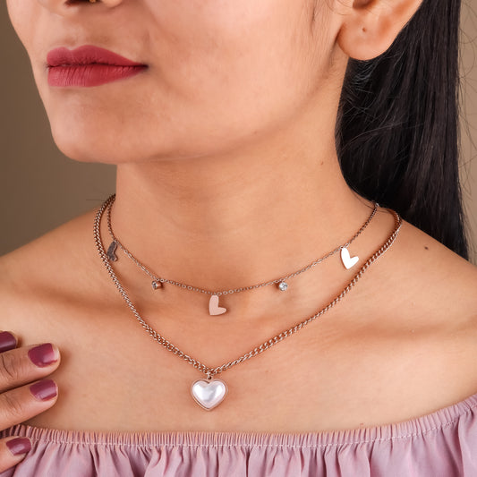 Rose gold double-layer heart charm necklace worn on neck with small hearts and heart pendant