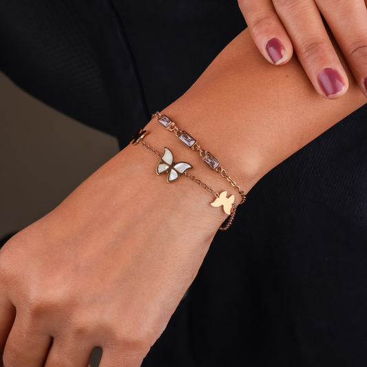Rose-gold bracelet with butterfly charms and square crystal link detailing on wrist